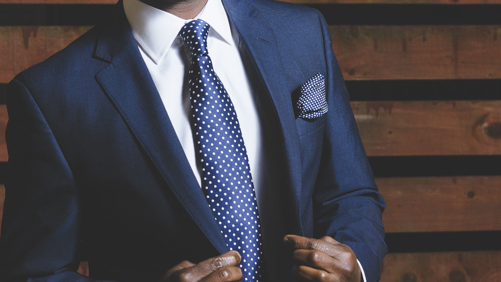 Tagungshotels und Tagungen in Nürnberg - schwarzer Mann im blauen Anzug mit blau-gepunkteter Krawatte und blau-gepunktetem Einstecktuch