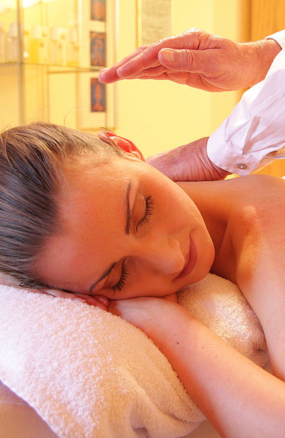 Wellness in Kempten im Allgäu - junge Frau auf einem Massagebett genießt Massage