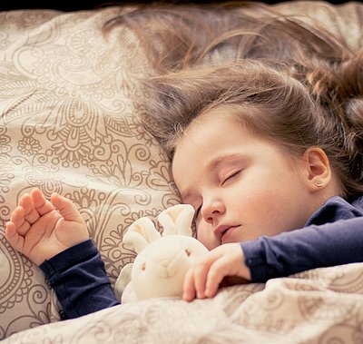 Kinderfreundliche Unterkünfte im Fichtelgebirge - kleines Mädchen mit Plüschhäschen liegt schlafend im Bett