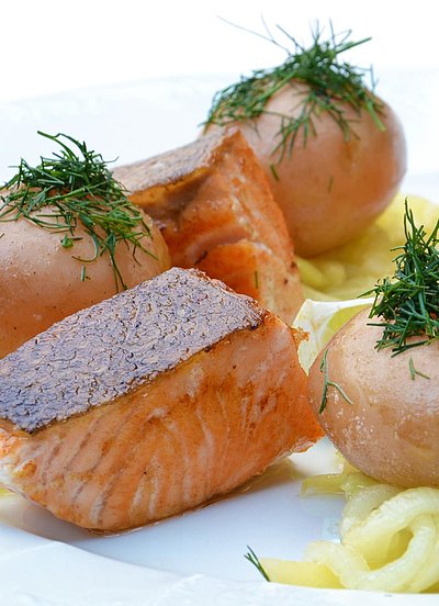 Gehobene Küche im Oberallgäu - weißer Teller gefüllt mit schön angelegtem Lachs und Kartoffeln