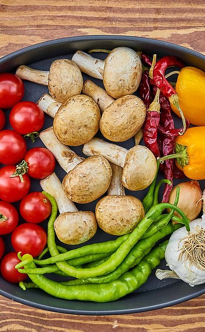 Regionale Erzeugnisse im Oberallgäu - große Pfanne mit verschiedenem Gemüse wie Tomate, Paprika und Knoblauch