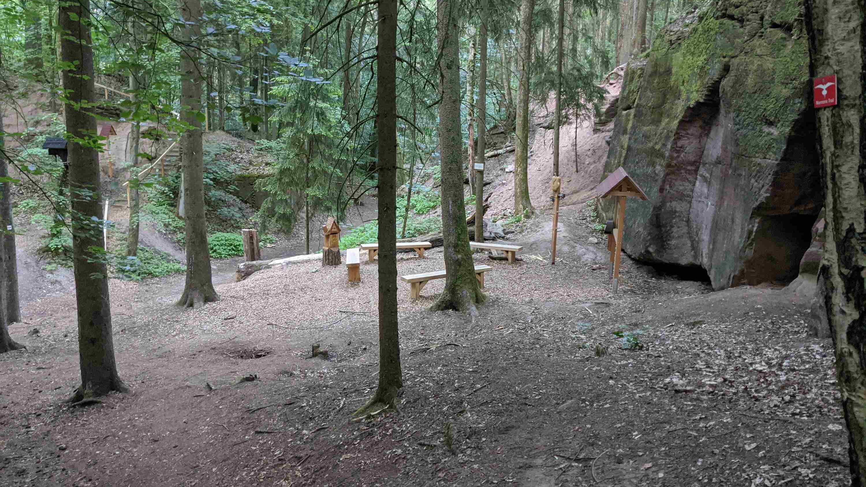 Baenke und Hinweisschild am Naturlehrpfad des Stadtwaldes Fuerth vor altem Steinbruch