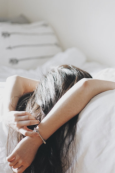 Pauschalen für eine Woche in Kempten - junge Frau liegt mit dem Rücken auf dem Bett und schaut zur Decke