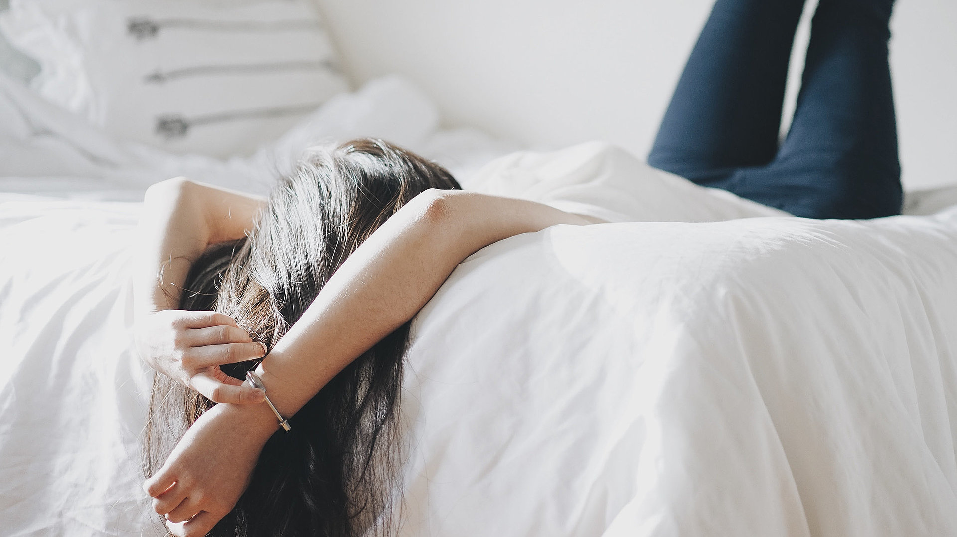 Pauschalen für Wochenenden in Unterfranken - junge Frau liegt mit dem Rücken auf dem Bett und schaut zur Decke 