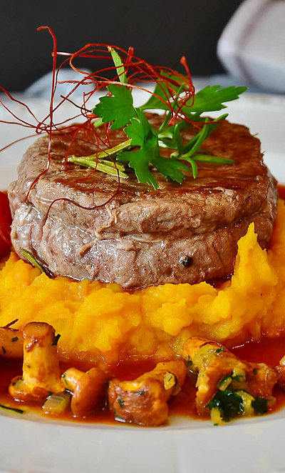 Gourmet-Restaurants in Oberbayern - weißer Teller u.a. gefüllt mit Filet und Pilzen im Gourmet-Stil angerichtet