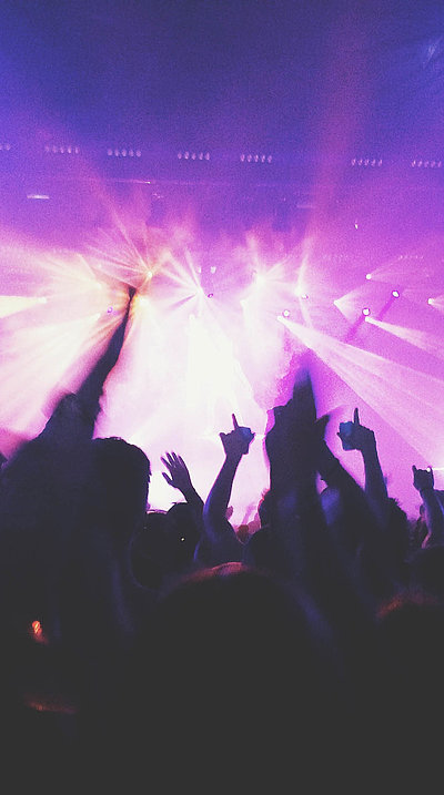 Events und Veranstaltungen in Oberfranken - in einem Club; viele Silhouetten feiern im violetten Scheinwerferlicht