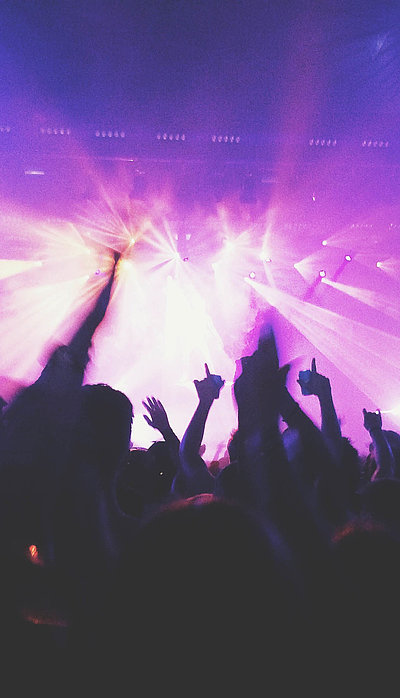 Events und Veranstaltungen in Kempten im Allgäu - in einem Club; viele Silhouetten feiern im violetten Scheinwerferlicht