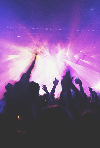 Events und Veranstaltungen in Oberbayern - in einem Club; viele Silhouetten feiern im violetten Scheinwerferlicht