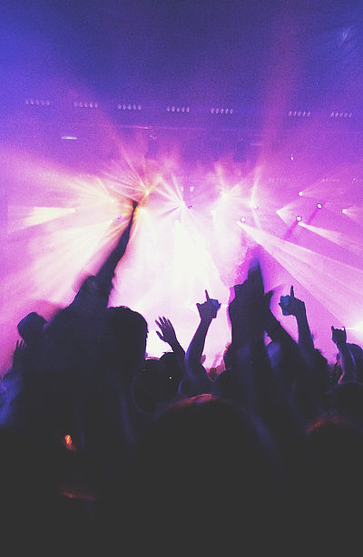 Events und Veranstaltungen in Nürnberg - in einem Club; viele Silhouetten feiern im violetten Scheinwerferlicht