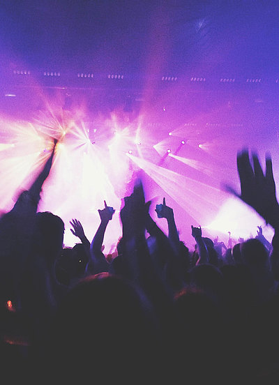 Events und Veranstaltungen in Unterfranken - in einem Club; viele Silhouetten feiern im violetten Scheinwerferlicht