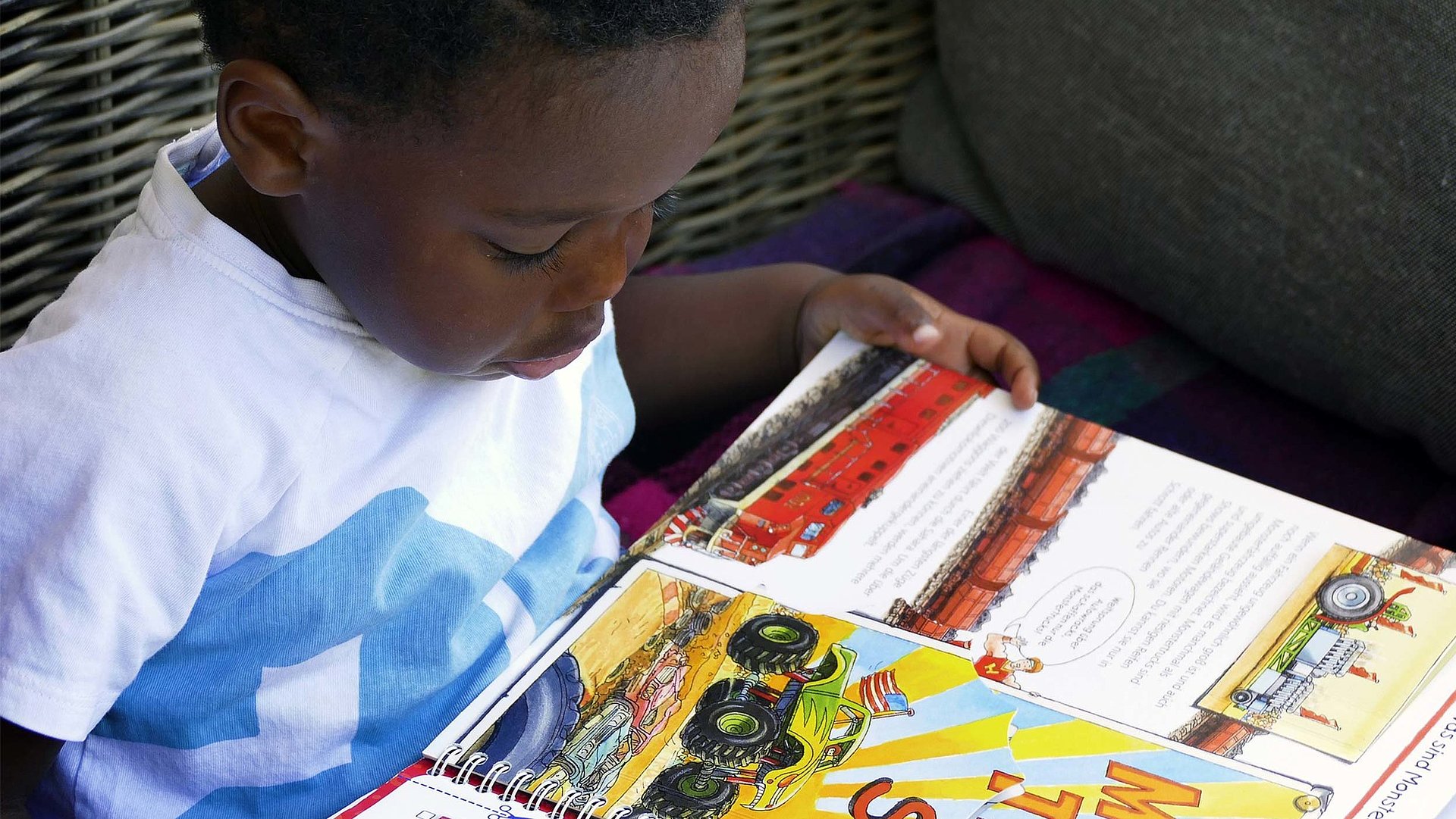 Kinderfreundliche Angebote in der Fränkische Schweiz - Erlebnisse für die gesamte Familie - schwarzes Kleinkind liest im Bilderbuch