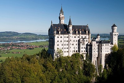 Schloss Neuschwanstein - im Hintergrund Ferienwohnungen, Hotels, Gasthöfe und Pensionen in der Region Ostallgäu