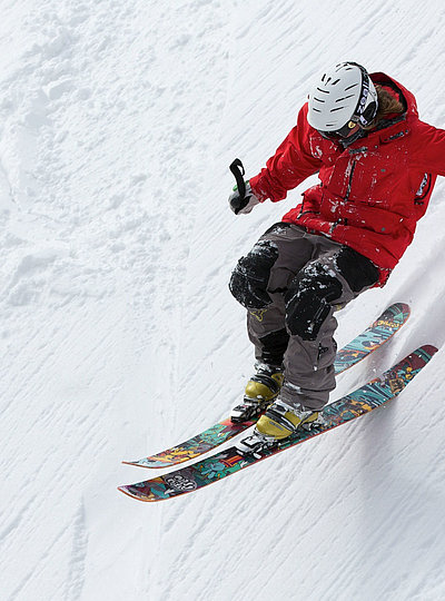 Anreize für Aktivitäten im Fichtelgebirge - Mann in Skiausrüstung fährt soeben Schnee-Hügel runter