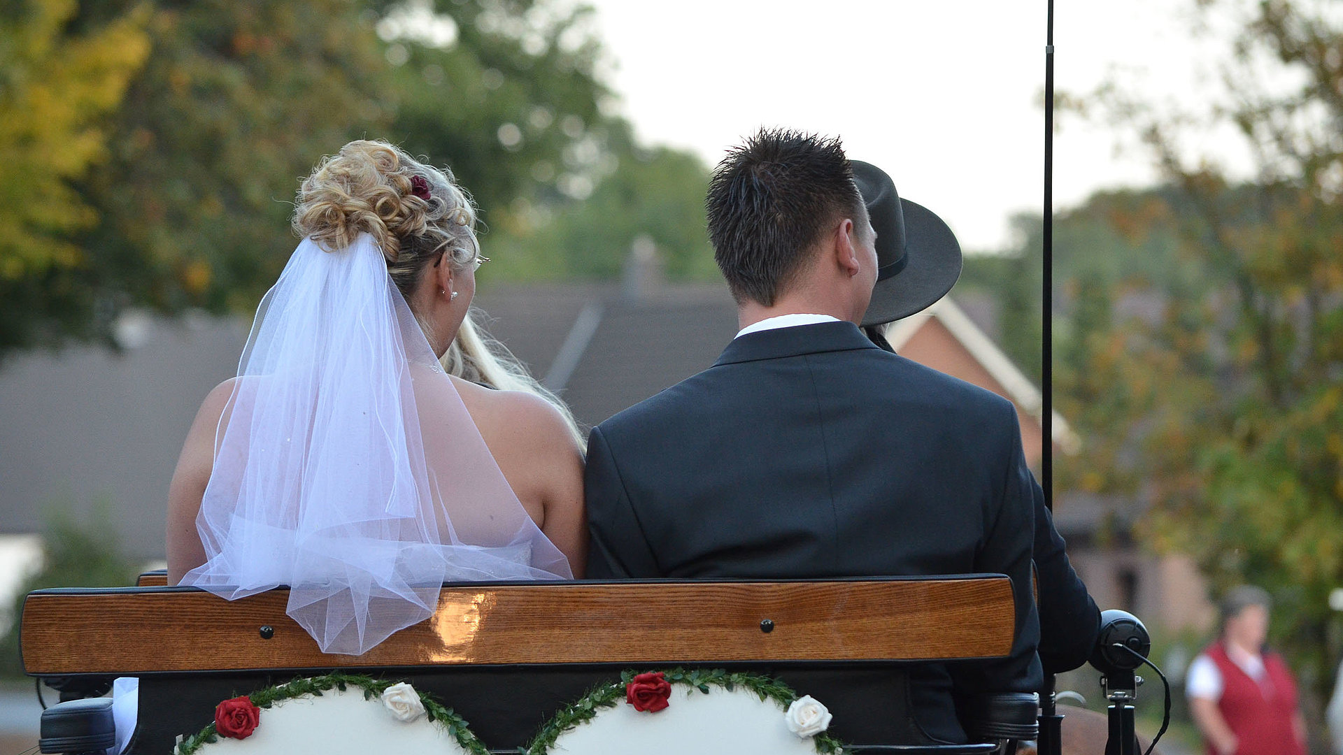 Heiraten in Nürnberg - Fokus auf Brautpaar auf einer Holzbank mit Rücken zur Kamera