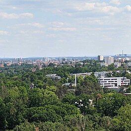 Blick vom Solarberg Fuerth in Richtung Fuerth. Die Stadt teils von Baeumen verdeckt. Nuernberger Fernsehturm im Hintergrund
