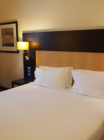 Übernachten im Panorama in Franken - sehr ordentliches Hotelzimmer mit großem Bett, warmer Nachtlampe und mittelgroßem Wandgemälde 