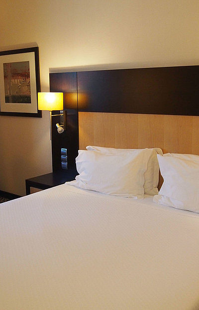 Hotels für Gruppen in Mittelfranken - sehr ordentliches Hotelzimmer mit großem Bett, warmer Nachtlampe und mittelgroßem Wandgemälde