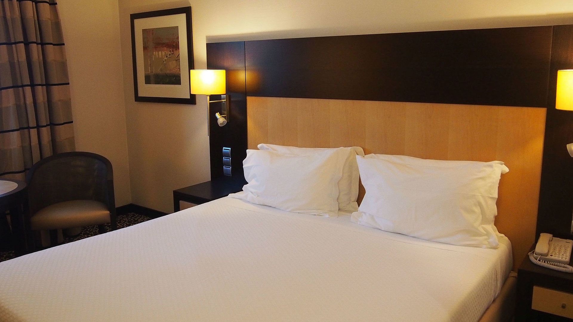 Behindertengerechte Unterkunft in Franken - sehr ordentliches Hotelzimmer mit großem Bett, warmer Nachtlampe und mittelgroßem Wandgemälde