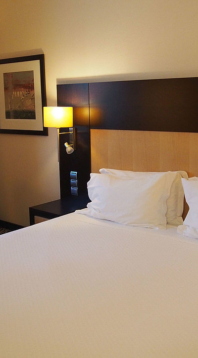 Übernachten im Video Oberfranken - sehr ordentliches Hotelzimmer mit großem Bett, warmer Nachtlampe und mittelgroßem Wandgemälde