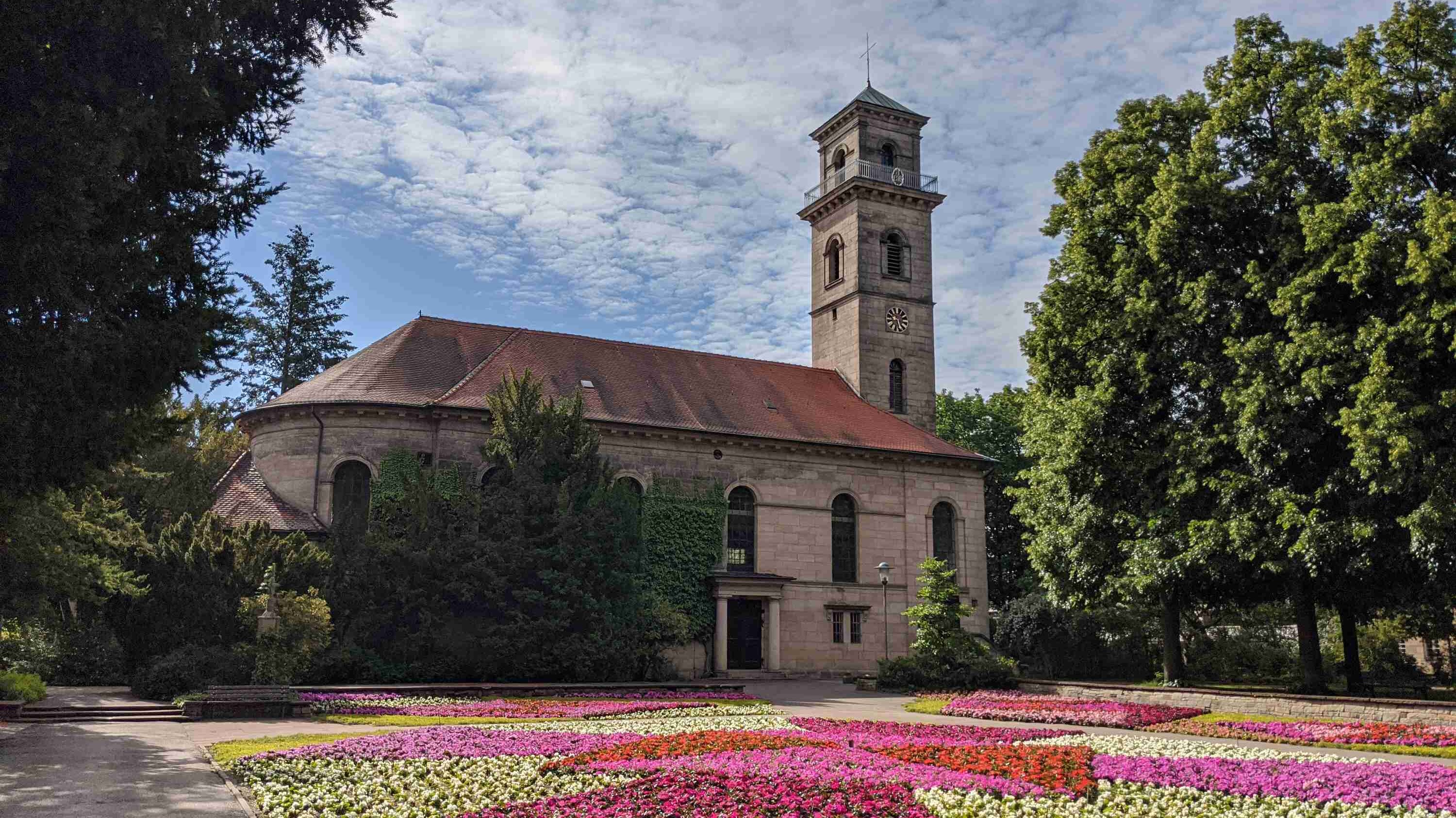 Die Auferstehungskirche im Stadtpark Fürth vor einem bunten Blumenmeer
