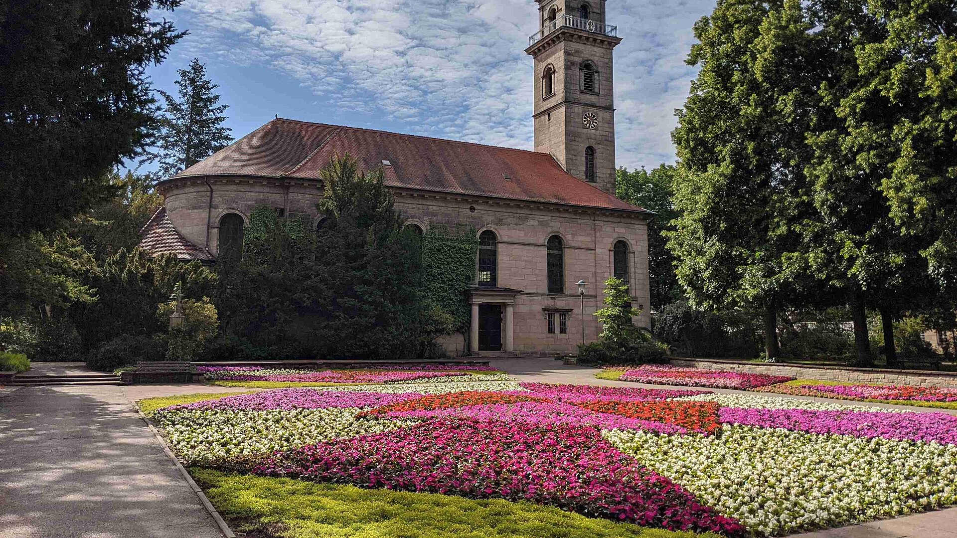 Die Auferstehungskirche im Stadtpark Fürth vor einem bunten Blumenmeer