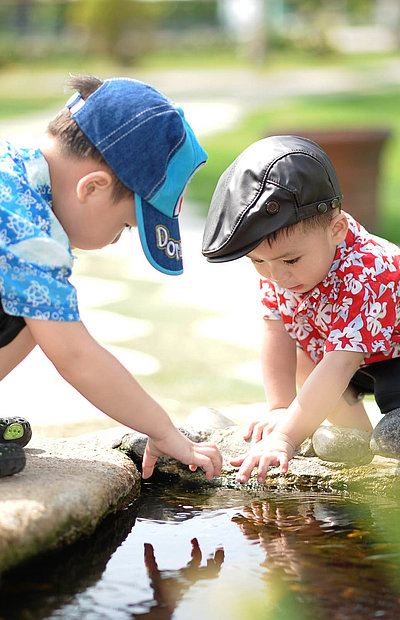 Kinderfreundliche Unterkünfte in Unterfranken - zwei kleine Jungs spielen zusammen am Teich