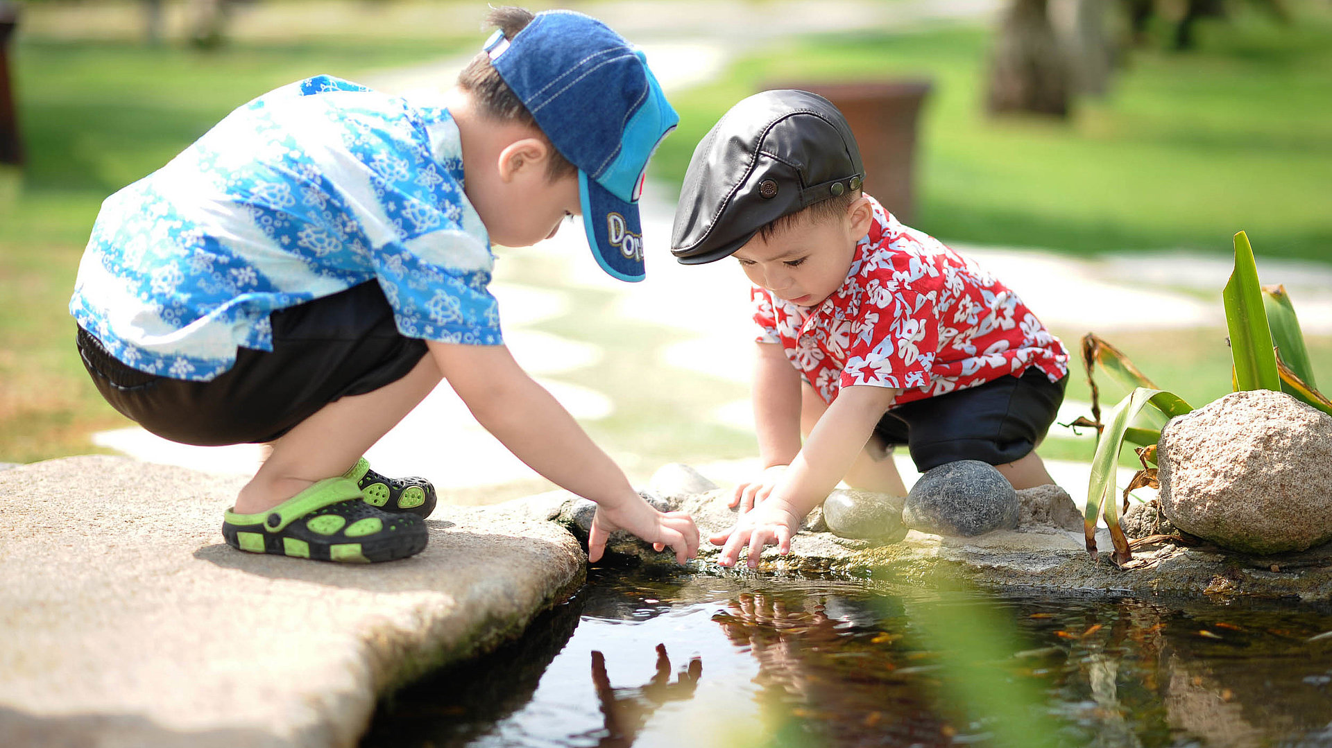 Kinderfreundliche Gastronomie im Fichtelgebirge - zwei Kleinkinder spielen bei schönem Wetter zusammen am Teich