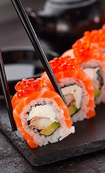 Gourmet-Restaurants in Unterfranken - mehrere Sushi auf Platte; eine wird mit Stäbchen gehalten