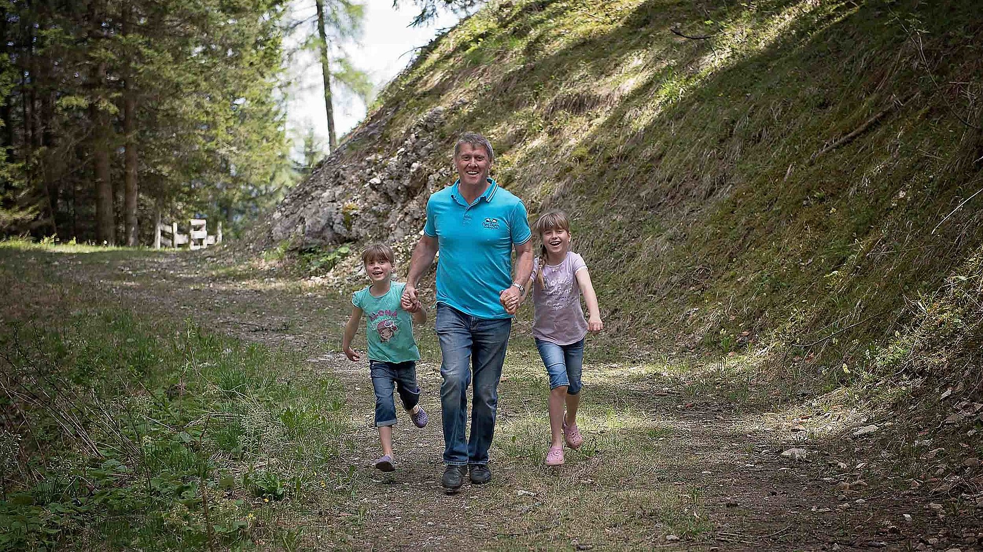 Kinderfreundliche Angebote im Fränkischen Seenland - Erlebnisse für die gesamte Familie - Mann läuft mit zwei Kindern auf einem Waldweg; mit einem Jungen und einem Mädchen