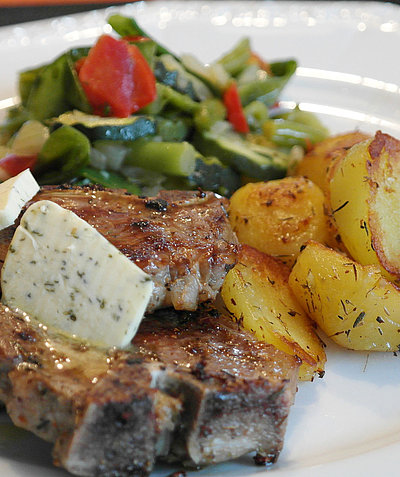 Mittagessen in Unterfranken - Teller gefüllt mit frischem Lamm, Kräuterbutter, gebratenen Kartoffeln und Salat