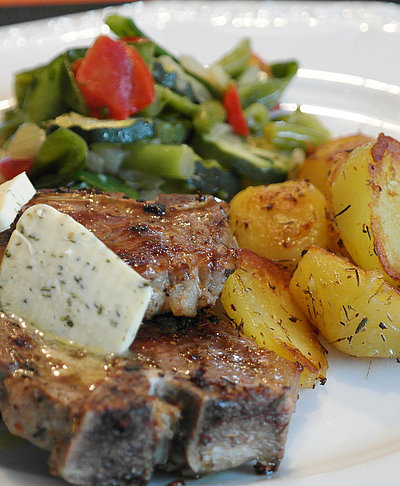 Griechische Küche im Oberallgäu - Teller gefüllt mit frischem Lamm, Kräuterbutter, gebratenen Kartoffeln und Salat