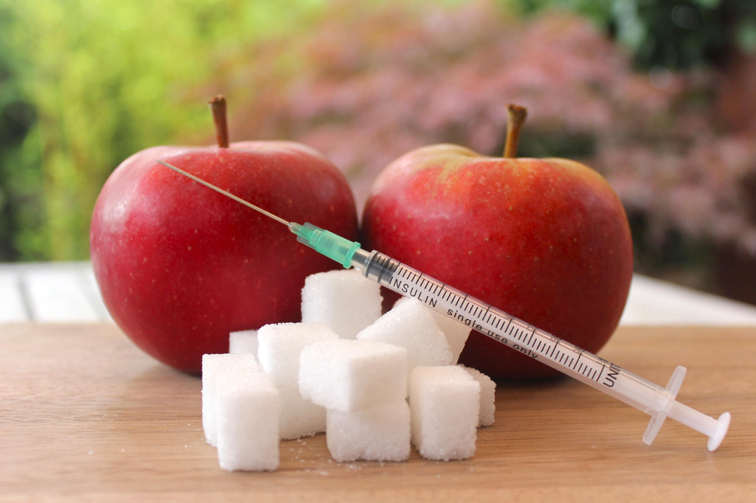 Diabetes Typ 2: Die ersten Schritte nach der Diagnose - 2 Äpfel und Zuckerstückchen sowie eine Insulinspritze. 