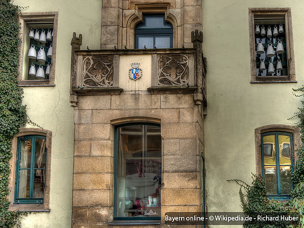 Zwischen den beiden Glockenspielhälften verschönert ein aus Porzellan gefertigtes Stadtwappen den Rathausbalkon.